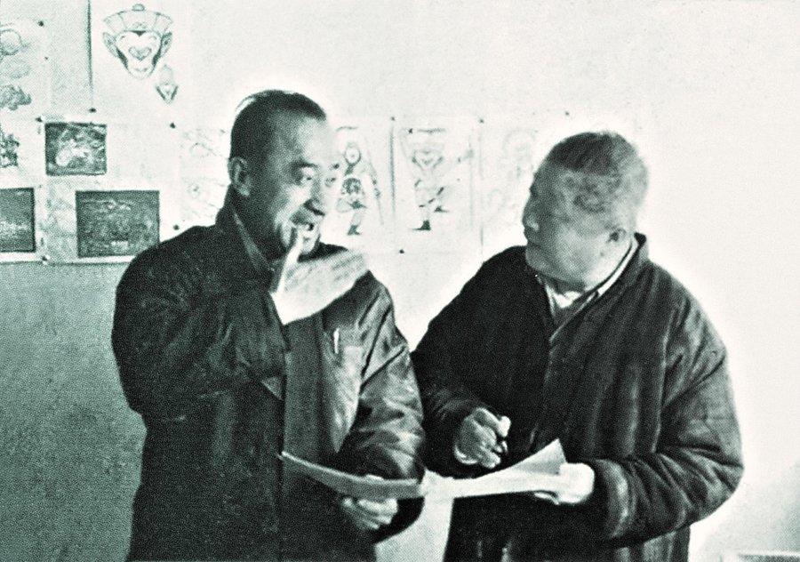 两位万氏兄弟在画室里交谈，墙上贴着猴王造型稿