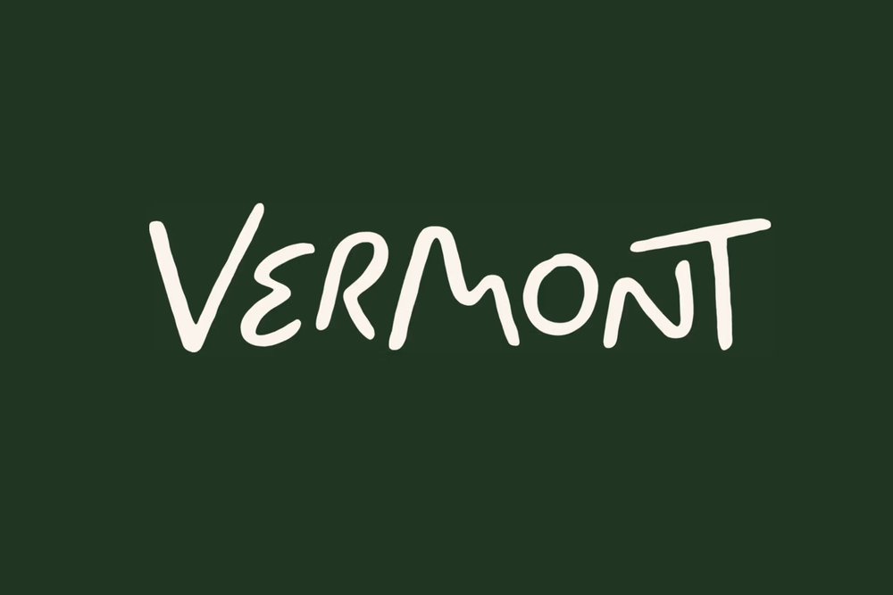 Vermont 新手写 wordmark：深绿底上米白色的 Vermont 字样
